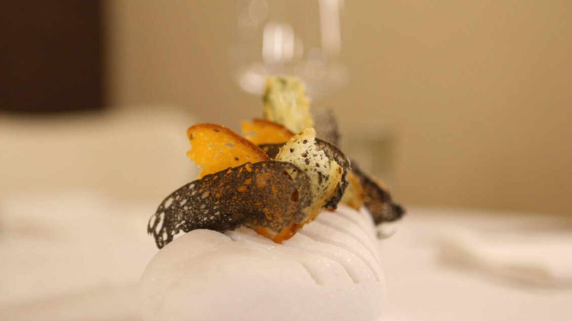 Ein kunstvoll angerichtetes Gericht auf einem weißen Teller. Es enthält bunte Zutaten und besondere Garnierungen. | © Artis