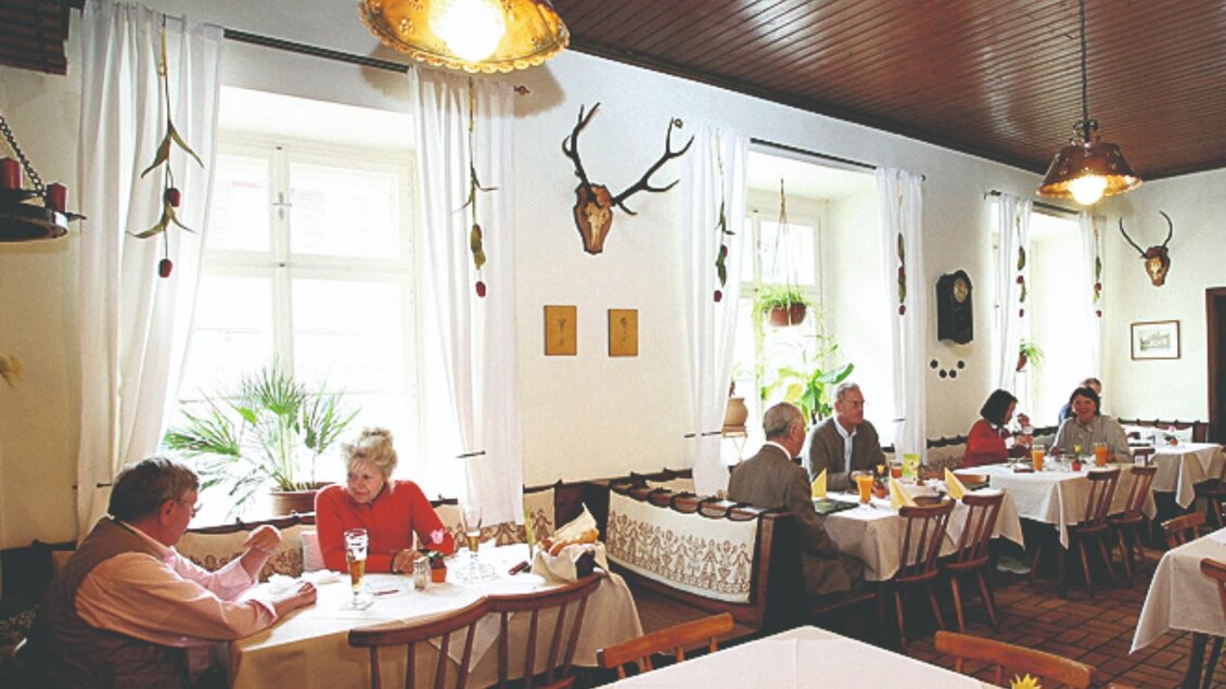 Gäste sitzen im traditionellen Speiseraum des Gasthauses. | © Brandhof