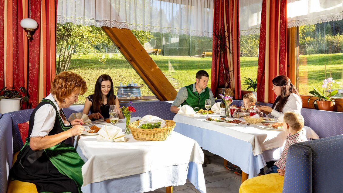 Ein gemütliches Restaurant mit einer Familie und Mitarbeitern, die gemeinsam essen. Viel natürliches Licht strömt durch die Fenster und schafft eine einladende Atmosphäre. | © Lipizzanerheimat-Schiffer