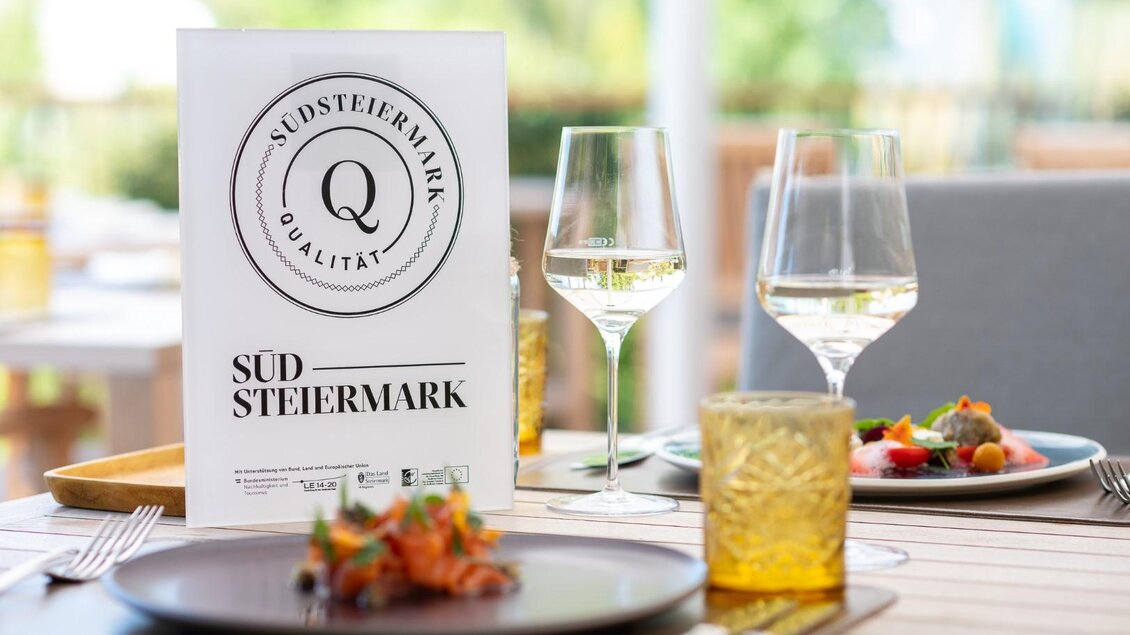 Ein elegantes Tischgedeck mit einem Menü aus der Südsteiermark. Dazu gehören Weingläser, farbenfrohe Speisen und eine ansprechende Tischdekoration. | © Rainer Ogrinigg |Landgut am Pößnitzberg