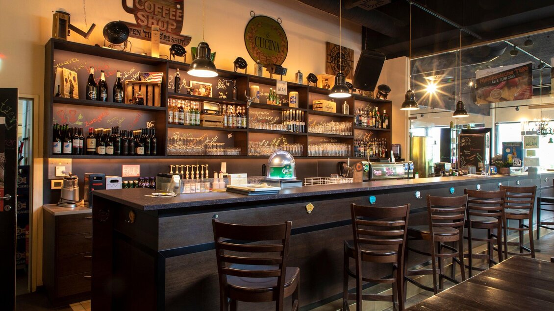 Eine gemütliche Bar mit einer Holztheke und zahlreichen Regalen voller Getränke. An den Wänden hängen verschiedene Dekorationen, und die Beleuchtung sorgt für eine einladende Atmosphäre. | © TV Region Graz - Lunghammer