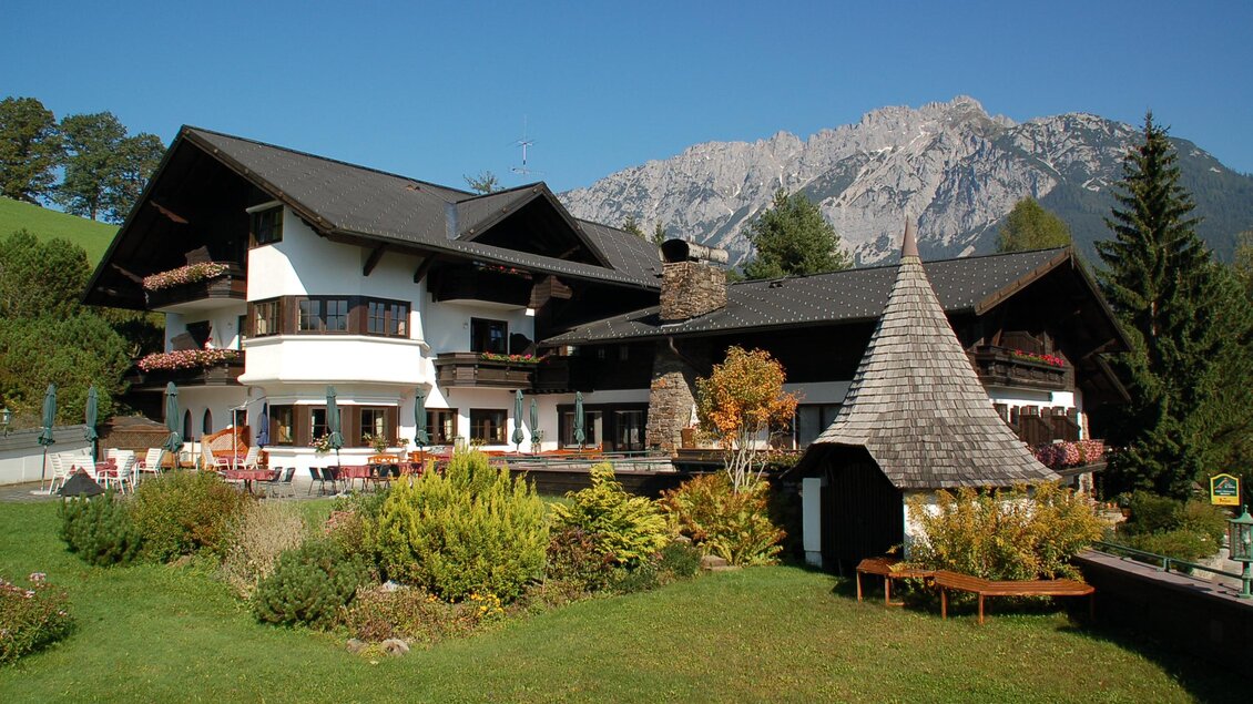 Ein charmantes Chalet mit einem großen Garten. Im Hintergrund sind majestätische Berge zu sehen. | © Restaurant Landhaus St. Georg