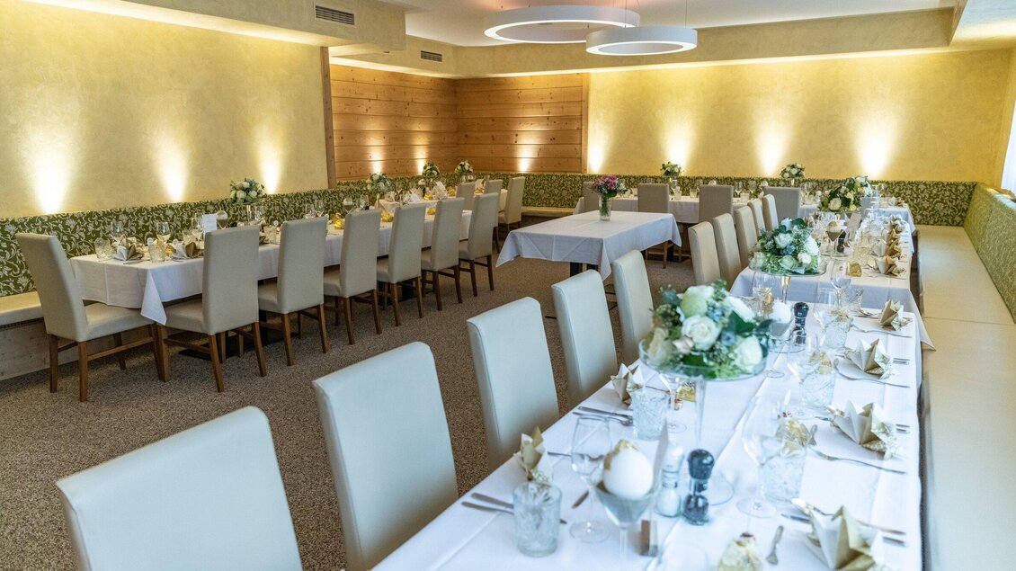 Ein eleganter Veranstaltungsraum mit langen Tischen und modernen Stühlen. Die Tische sind festlich gedeckt und mit Blumen dekoriert. | © Jürgen Fuchs