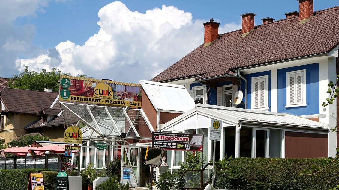Ein Restaurant mit dem Namen "Cuk" bietet Pizzeria und Café an. Die Fassade ist bunt gestrichen und der Himmel ist wolkig. | © TV Region Graz - Lunghammer