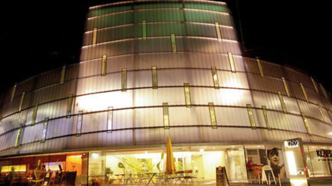 Modernes, rundes Gebäude mit beleuchteter Glasfassade und Restaurant im Erdgeschoss. | © Restaurant Rondo