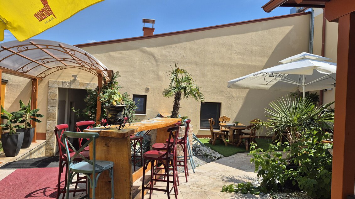 Ein einladender Außenbereich mit gemütlichen Sitzgelegenheiten und Pflanzen. Sonnenschirme sorgen für Schatten und eine entspannte Atmosphäre. | © TV Hochsteiermark