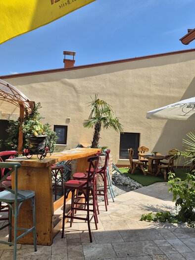 An inviting outdoor area with cozy seating and plants. Umbrellas provide shade and a relaxed atmosphere. | © TV Hochsteiermark