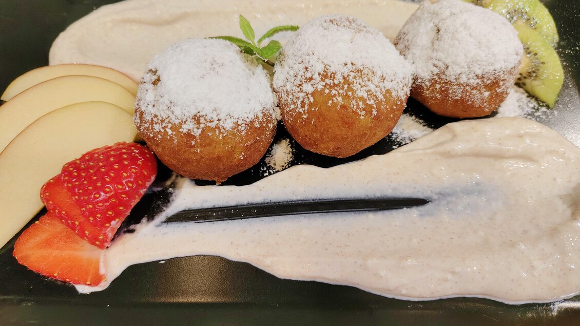 Drei gebackene Apfelknödel mit Zimt-Sauerrahmsauce, Erdbeeren, Apfelspalten und Kiwi im Restaurant Steiramichl in den Stadtsälen Voitsberg.  | © © Steiramichl