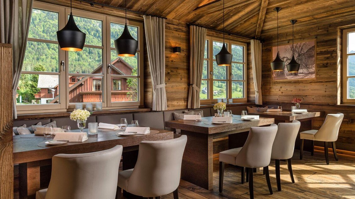 Ein gemütliches Restaurant mit Holzwänden und großen Fenstern. Die Tische sind elegant gedeckt und die Atmosphäre ist einladend. | © Mondi Resort