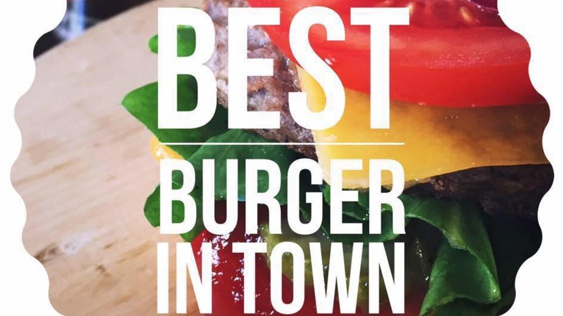 Ein köstlicher Burger mit frischen Zutaten, darunter Tomaten, Salat und Zwiebeln. Der Schriftzug "Best Burger in Town" hebt die Qualität hervor. | © Walter.Grill.Burger