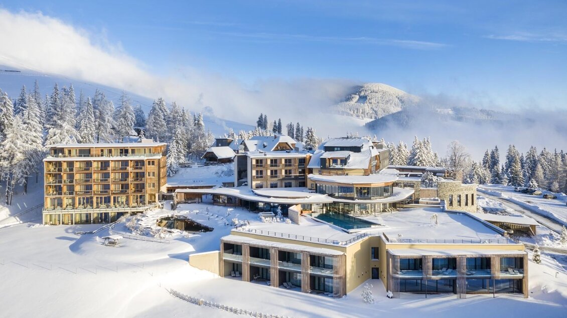 Hier sieht man eine Luftaufnahme im Winter vom gesamten Areal vom Almwellness Hotel Pierer.  | © Almwellness Hotel Pierer