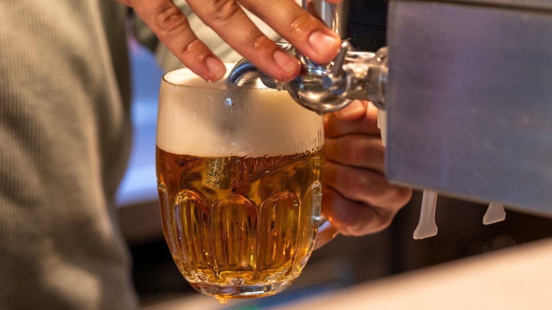 Ein Bier wird aus einem Zapfhahn in ein Glas gefüllt. Der Schaum ist reichhaltig und das Bier ist goldfarben. | © Hotel Alpen Arnika