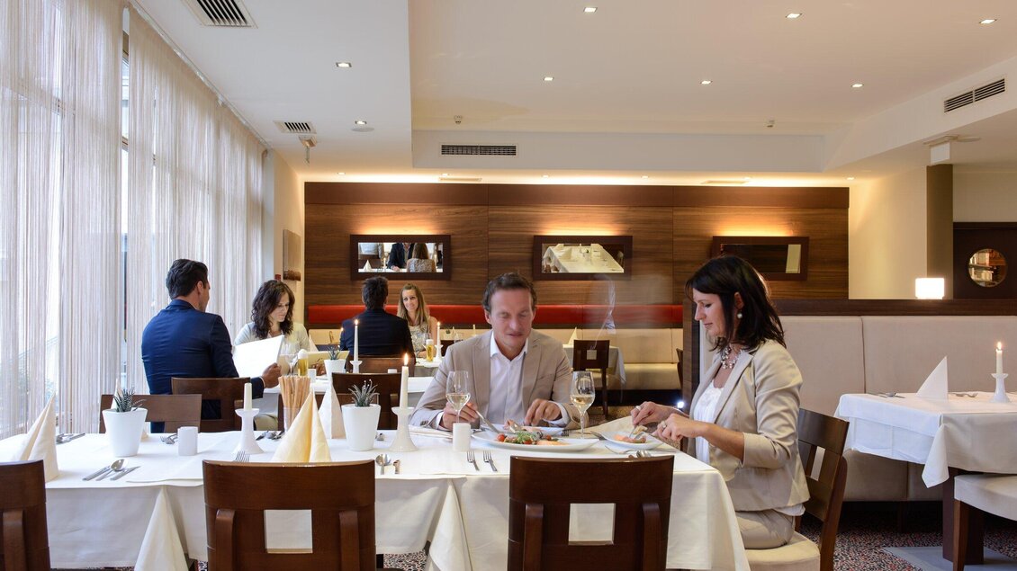 Ein elegantes Restaurant mit schön gedeckten Tischen. Gäste genießen ihr Essen in einem stilvollen Ambiente. | © Ulf Thausing
