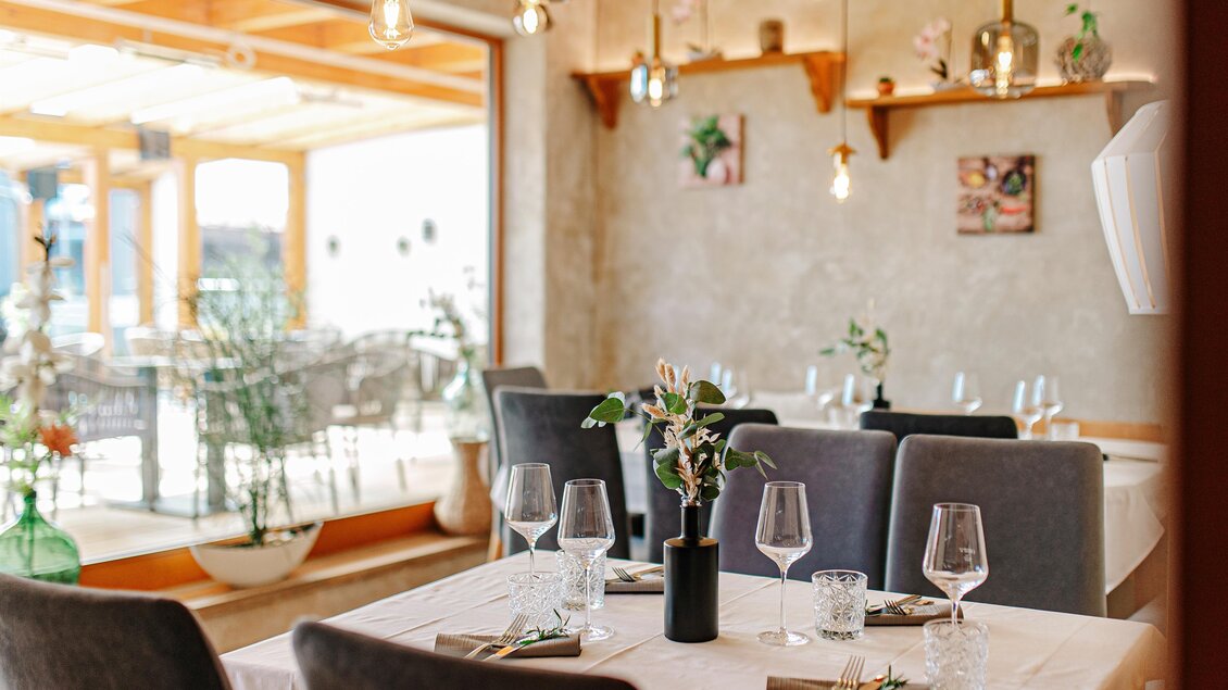 Ein elegantes Restaurant mit einem hellen, modernen Ambiente. Tische sind stilvoll gedeckt und mit Blumen dekoriert. | © Familie Wachmann