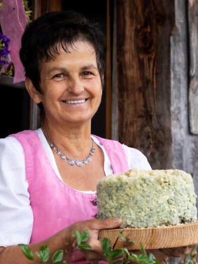 Dame mit Steirerkas vor der Hütte