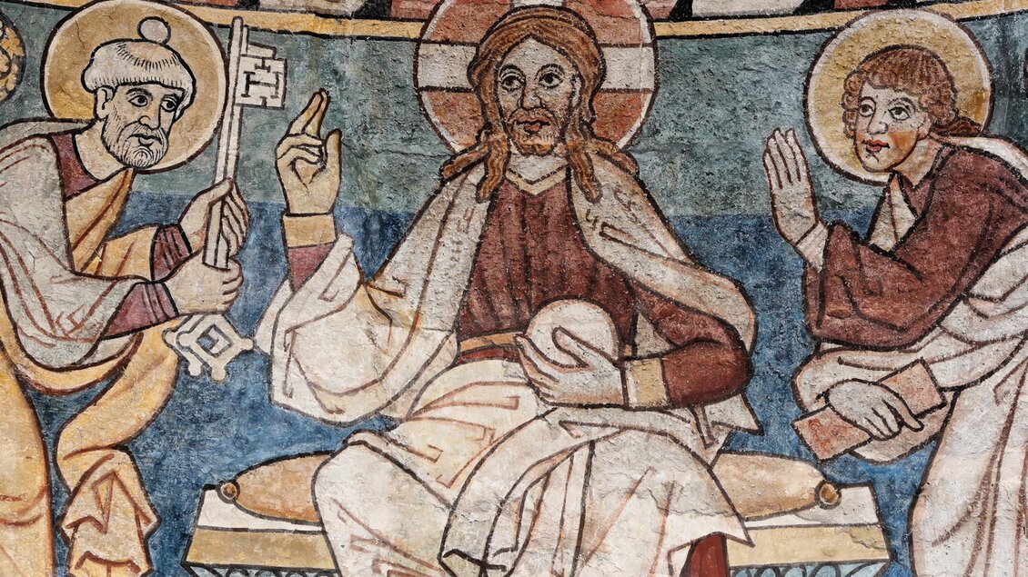 Eine historische Wandmalerei, die Jesus Christus im Mittelpunkt zeigt, umgeben von zwei Figuren. Die Szene vermittelt eine religiöse Atmosphäre mit lebendigen Farben und traditioneller Ikonografie. | © Tourismusverband Oststeiermark