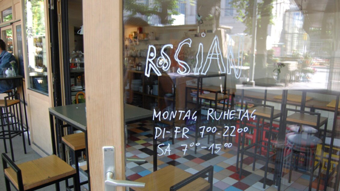 Ein Restaurant mit dem Namen "RSSIAN" ist zu sehen. Die Öffnungszeiten sind auf dem Fenster aufgeschrieben. | © Rossian