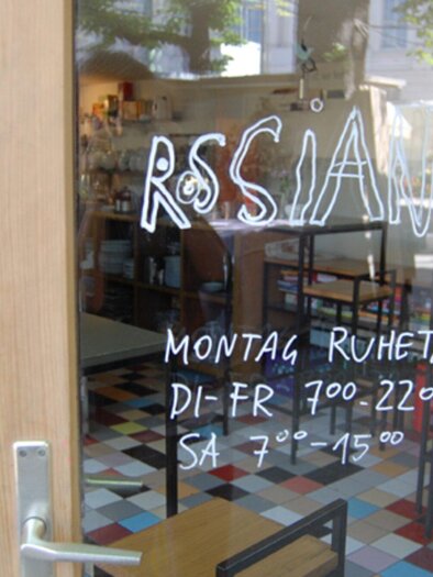 A restaurant named "RSSIAN" is visible. The opening hours are written on the window. | © Rossian