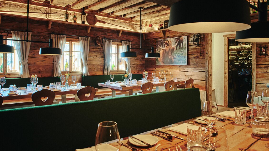 Ein gemütliches Restaurant mit Holzdekor und gedeckten Tischen. Große Fenster sorgen für helles Licht und eine einladende Atmosphäre. | © Felix Wernios