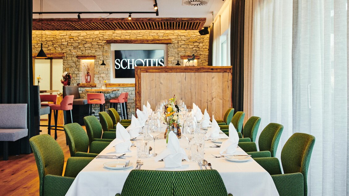Ein elegant gedeckter Tisch in einem stilvollen Restaurant. Im Hintergrund ist eine moderne Bar mit Holz- und Steinelementen zu sehen. | © Felix Werinos