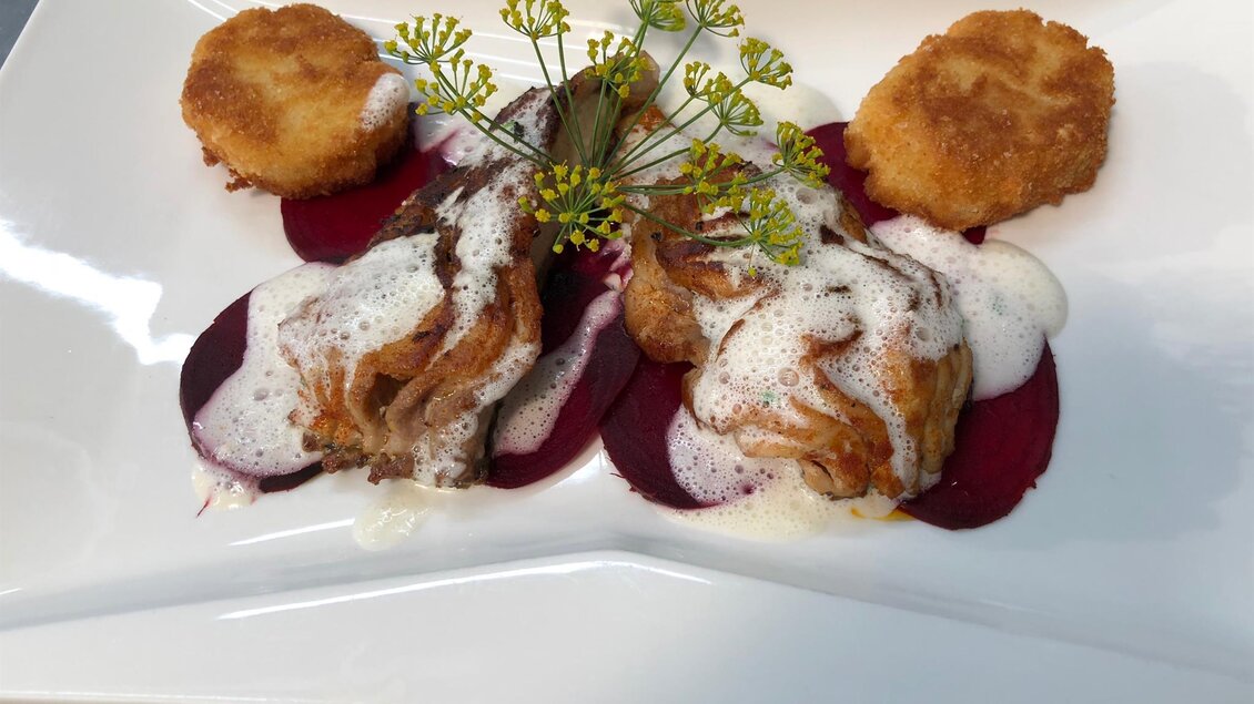 Ein elegantes Gericht mit gefrorenem Fisch, garniert mit einer schaumigen Sauce und Beetrootscheiben. Dazu gibt es knusprige Kartoffelplätzchen. | © Schaller's Gastwirtschaft