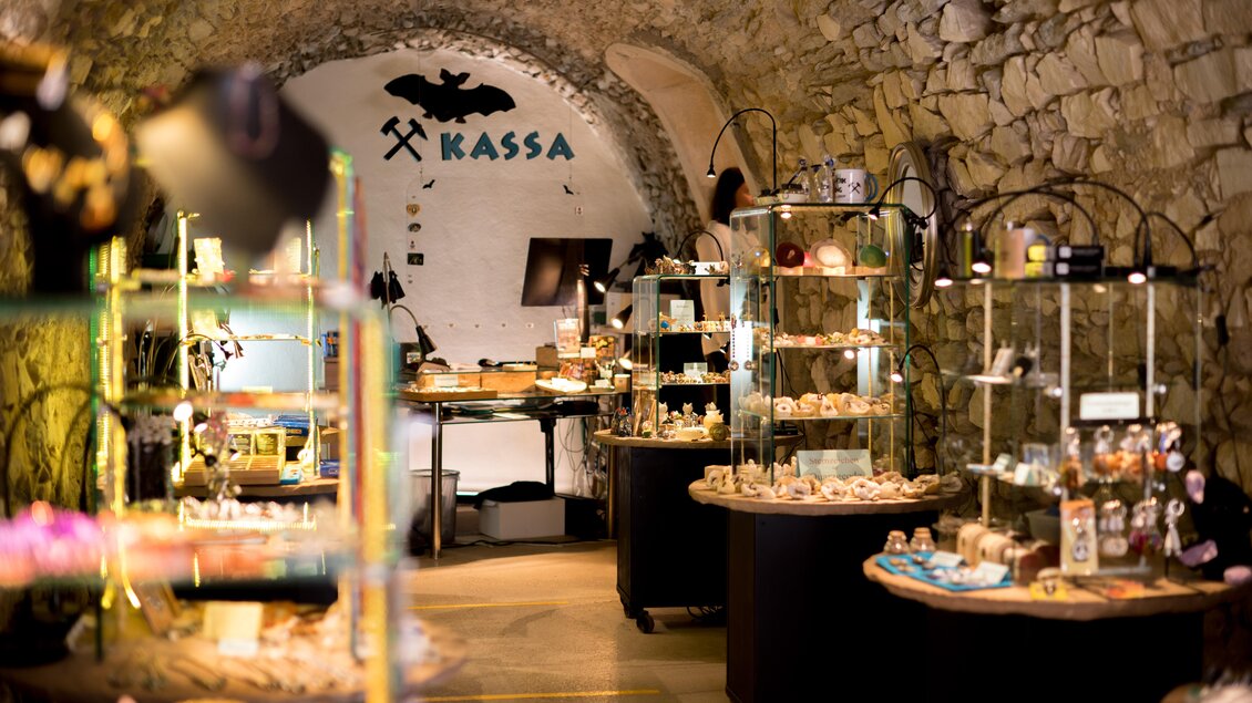 Ein gemütlicher Laden mit Steingewölbe, der verschiedene Auslagen mit kunsthandwerklichen Produkten zeigt. Der Bereich für die Kasse ist deutlich gekennzeichnet. | © Anita Fössl