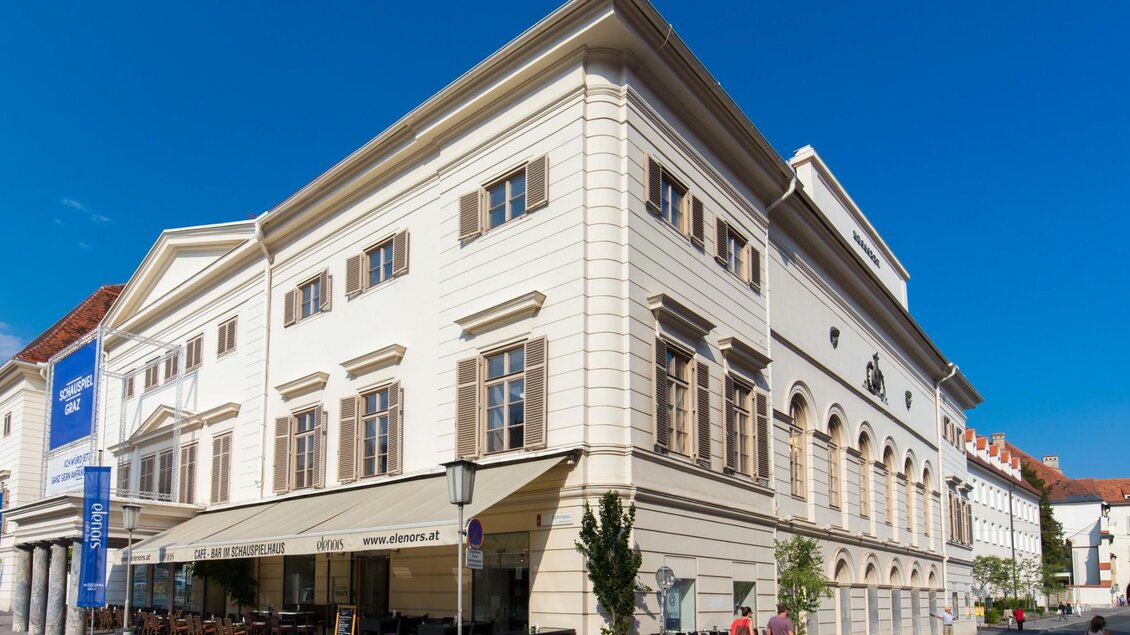 Fassade des Schauspielhauses Graz mit Straßencafé und Passanten bei Tag | © Graz Tourismus - Harry Schiffer