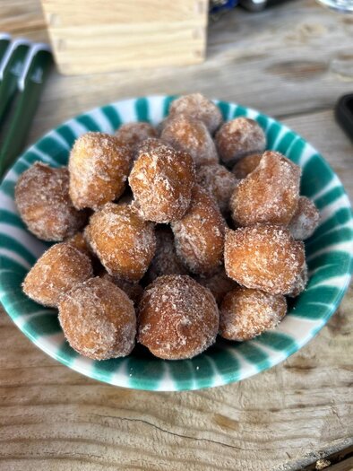 A bowl of small, fried dough balls, sprinkled with sugar. The balls are golden brown and look delicious. | © Schladminger Alm