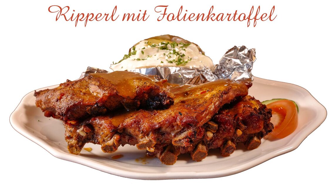 Saftige Rippchen mit einem Folienkartoffel und Sour Cream. Dazu ein frischer Tomatenscheibe. | © Foto TOM