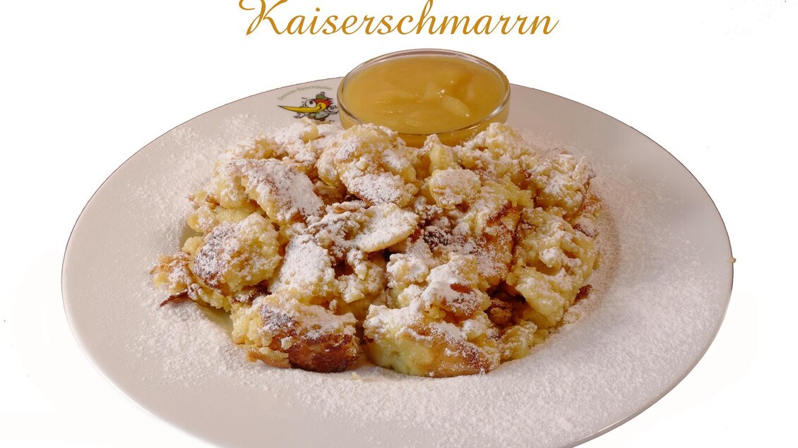 Ein leckerer Kaiserschmarrn auf einem Teller, bestreut mit Puderzucker. Dazu gibt es ein Schälchen mit Apfelmus. | © Foto TOM