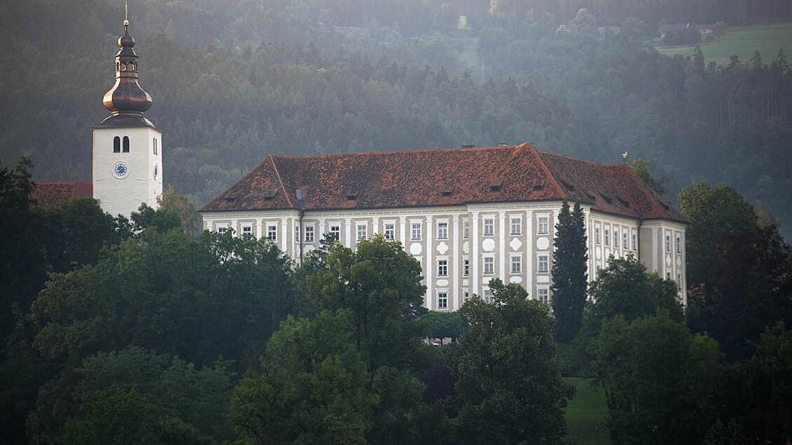Eine historische Gebäude im Grünen, umgeben von Bäumen. Der Turm mit der Uhr ist ein markantes Merkmal des Gebäudes. | © Enrico Caracciolo
