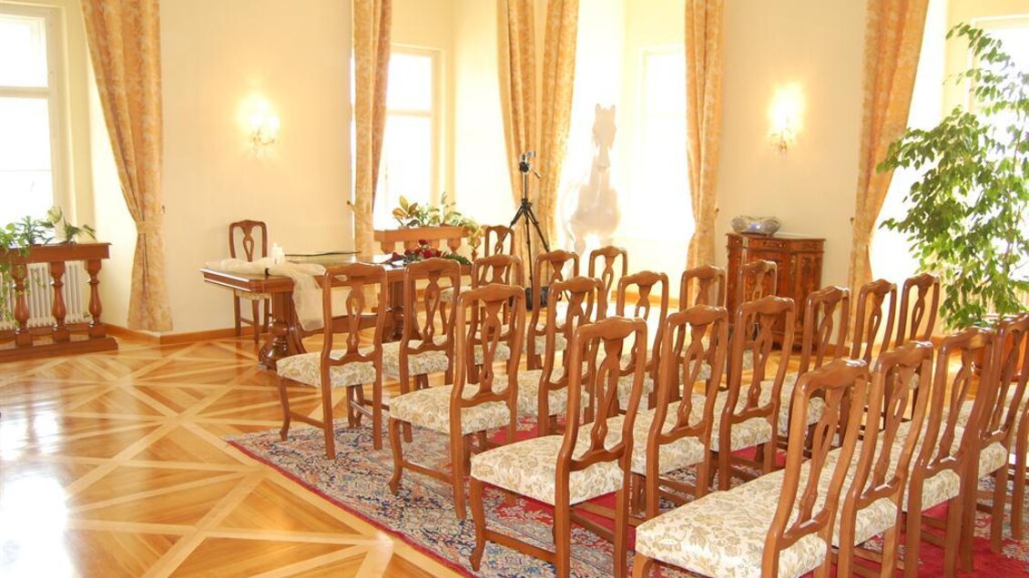 Ein eleganter Raum mit hölzernen Stühlen und einem schönen Parkettboden. Die Wände sind mit Vorhängen dekoriert, und es gibt einige Pflanzen. | © www.piber.com