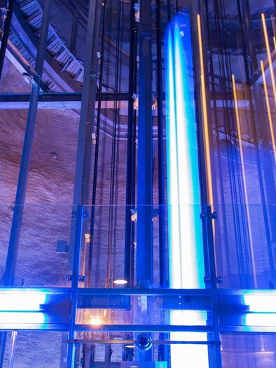 Ein modernes Aufzugssystem mit blauen und weißen Lichtern. Die Konstruktion ist futuristisch und gut beleuchtet. | © Graz Tourismus - Harry Schiffer