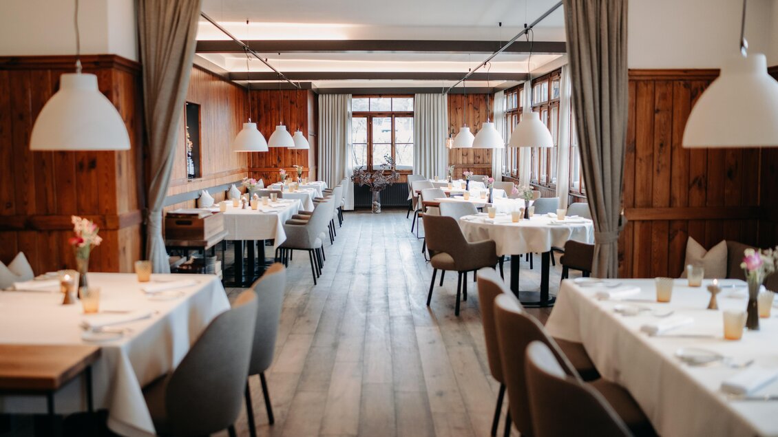 Ein elegantes Restaurant mit Holzvertäfelung und hellen Tischen. Große Fenster sorgen für viel natürliches Licht und eine einladende Atmosphäre. | © Hutter