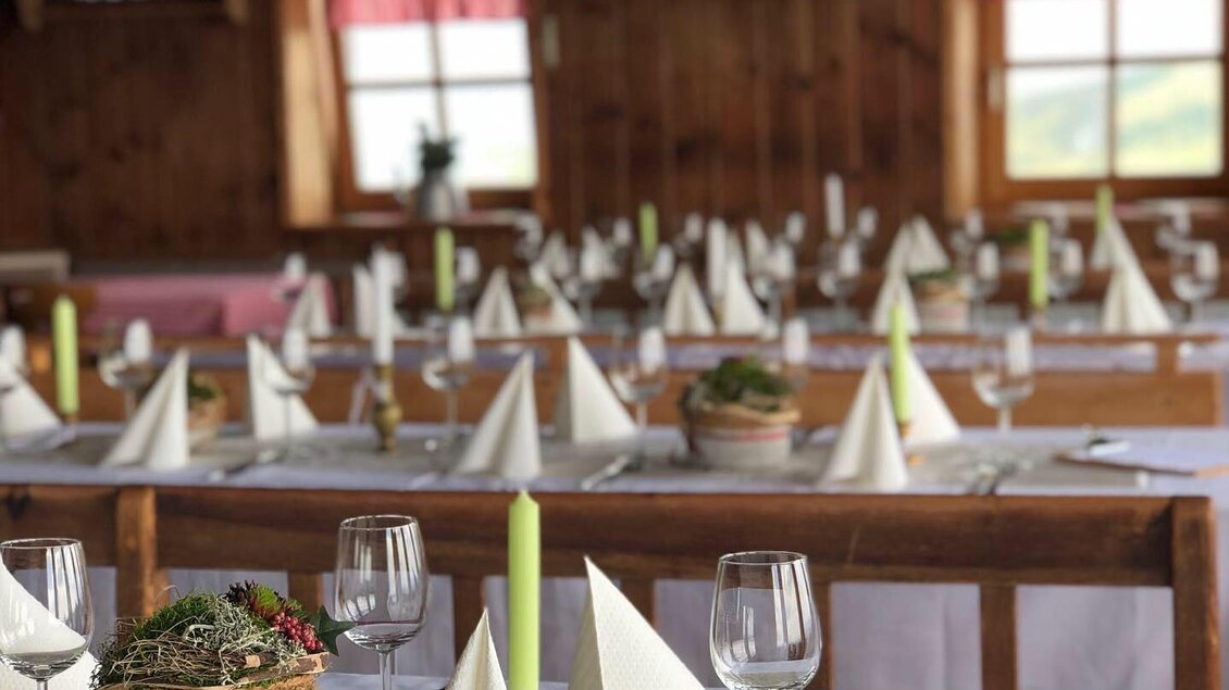 Ein gemütlicher Speisesaal mit gedeckten Tischen. Die Tische sind elegant dekoriert mit Servietten und Kerzen, um eine einladende Atmosphäre zu schaffen. | © Michael Fischer