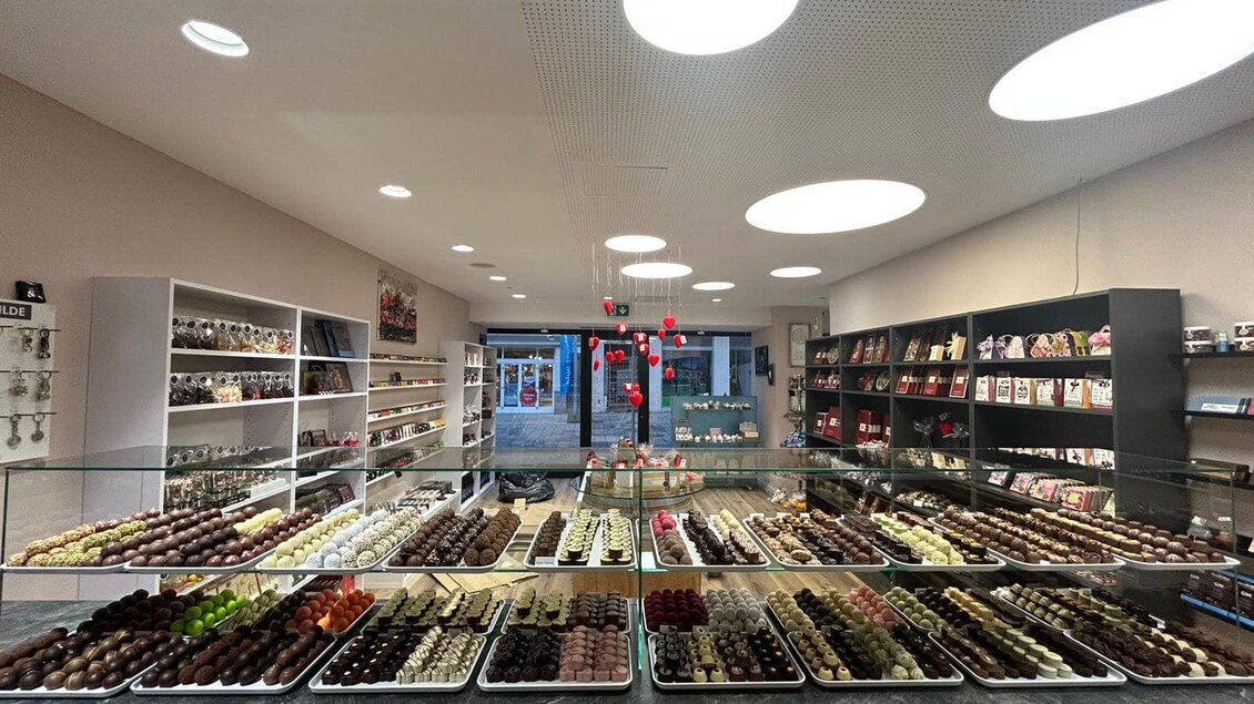 Ein elegantes Schokoladengeschäft mit einer Vielzahl von Pralinen und Süßigkeiten. Regale voller Köstlichkeiten laden zum Schmecken und Entdecken ein. | © Sterner