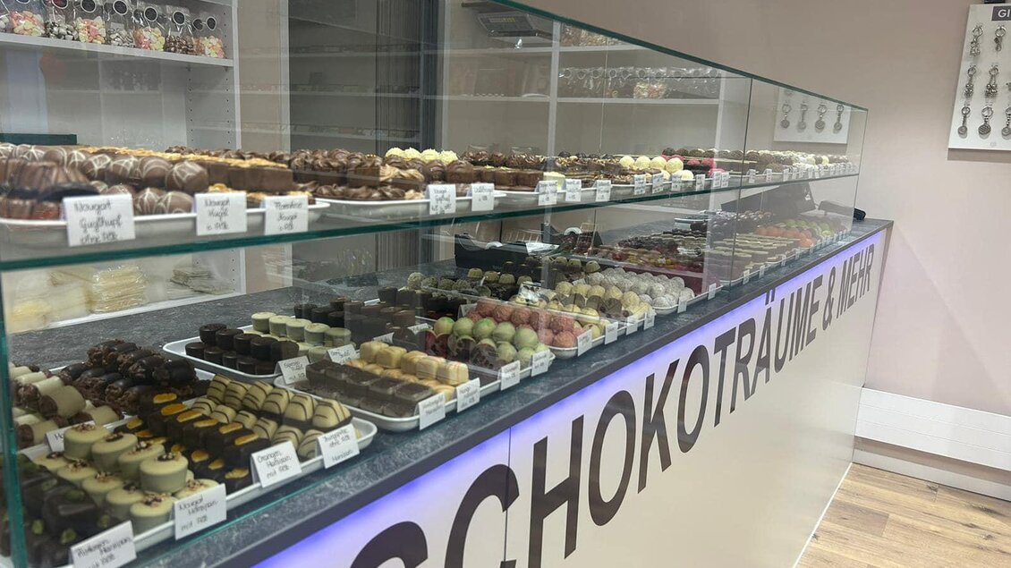 Eine gläserne Vitrine voller köstlicher Pralinen und Schokoladenstücke. Die Süßigkeiten sind bunt und vielfältig dekoriert, ideal für Schokoladenliebhaber. | © Sterner