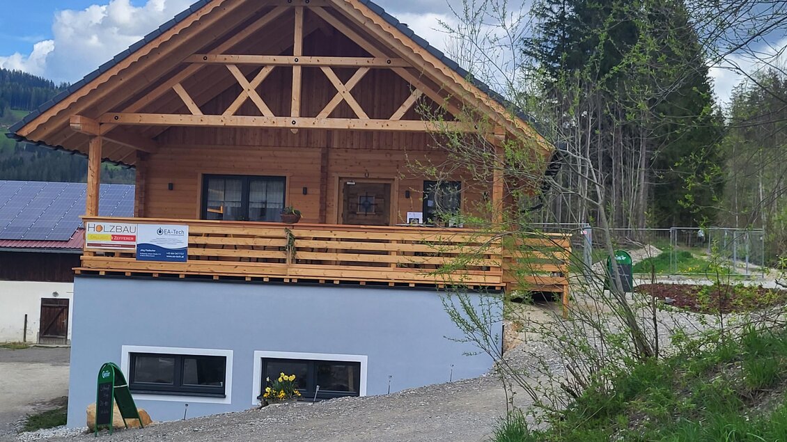 Ein traditionelles Holzhaus mit einem großen Balkon. Es liegt in einer ruhigen, natürlichen Umgebung mit grünen Bäumen im Hintergrund. | © TV Hochsteiermark |  Andrea Stelzer