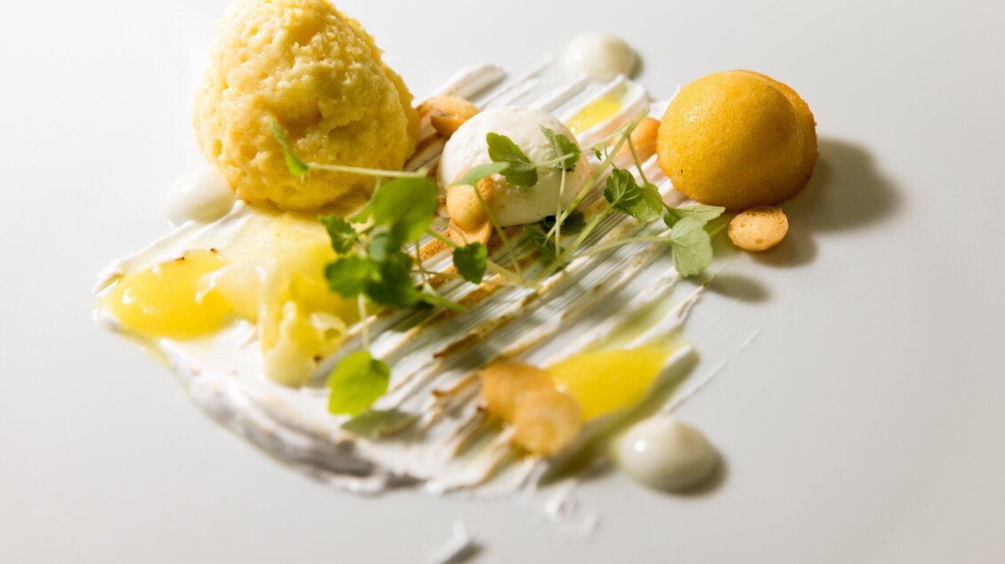 Eine kunstvolle Dessertpräsentation mit verschiedenen Eiskugeln, Nüssen und Garnierungen. Die Farben und Texturen sind ansprechend und frisch. | © TV Region Graz - Harry Schiffer