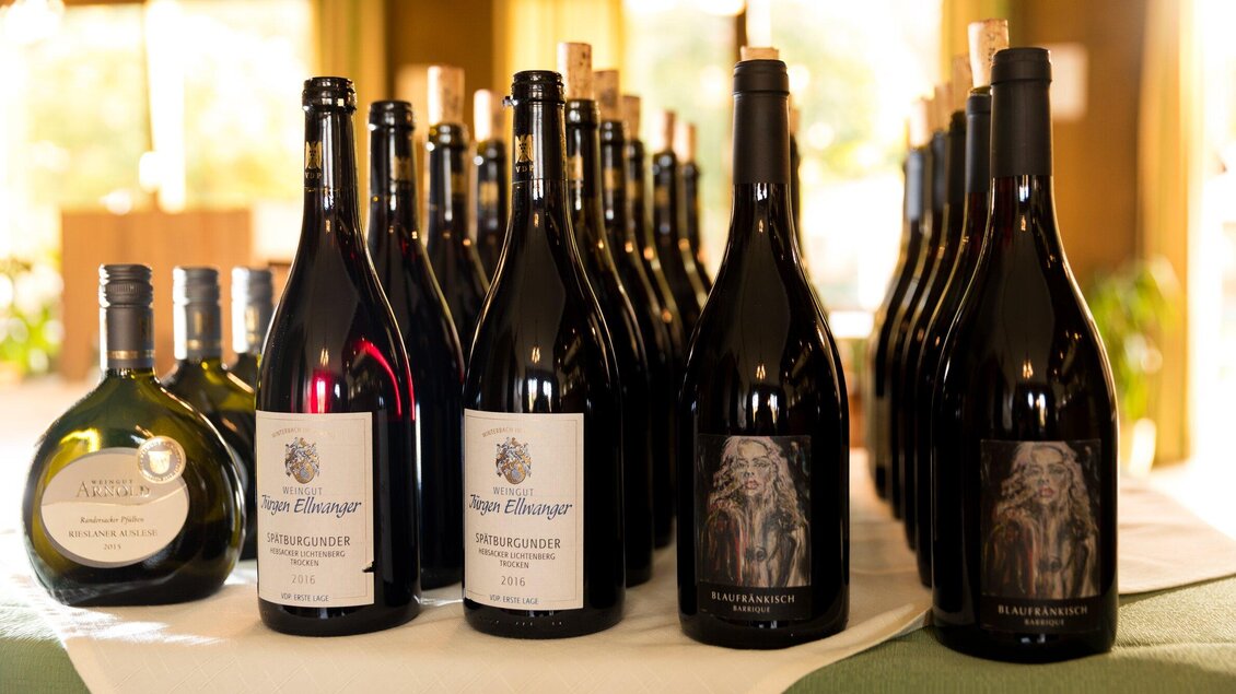 Eine Auswahl von Weinflaschen in unterschiedlicher Größe steht auf einem Tisch. Die Flaschen sind schön angeordnet und stammen von verschiedenen Weingütern. | © TV Region Graz - Harry Schiffer