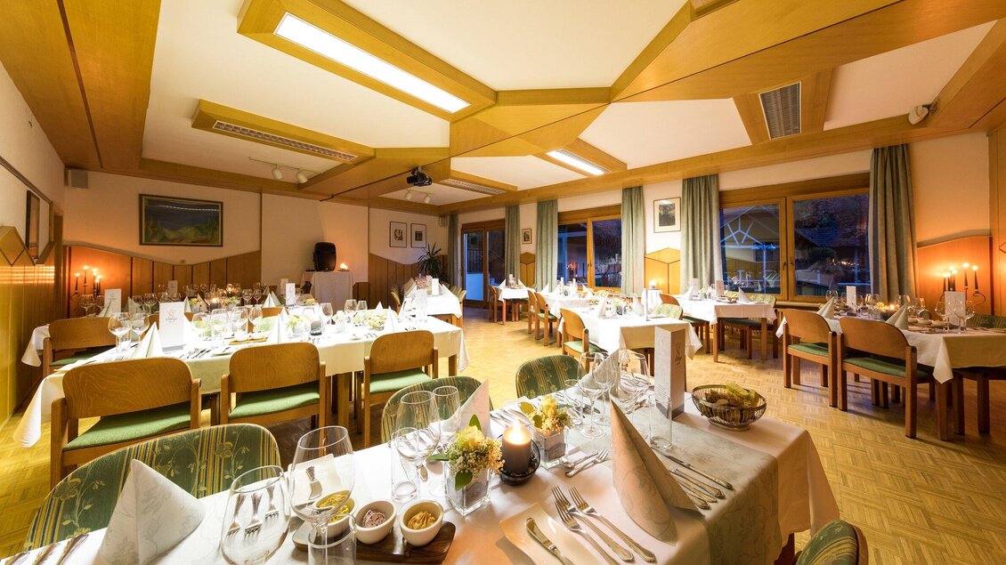 Ein elegantes Restaurant mit gedeckten Tischen und einer gemütlichen Atmosphäre. Große Fenster lassen warmes Licht herein und bieten einen Blick nach draußen. | © TV Region Graz - Harry Schiffer