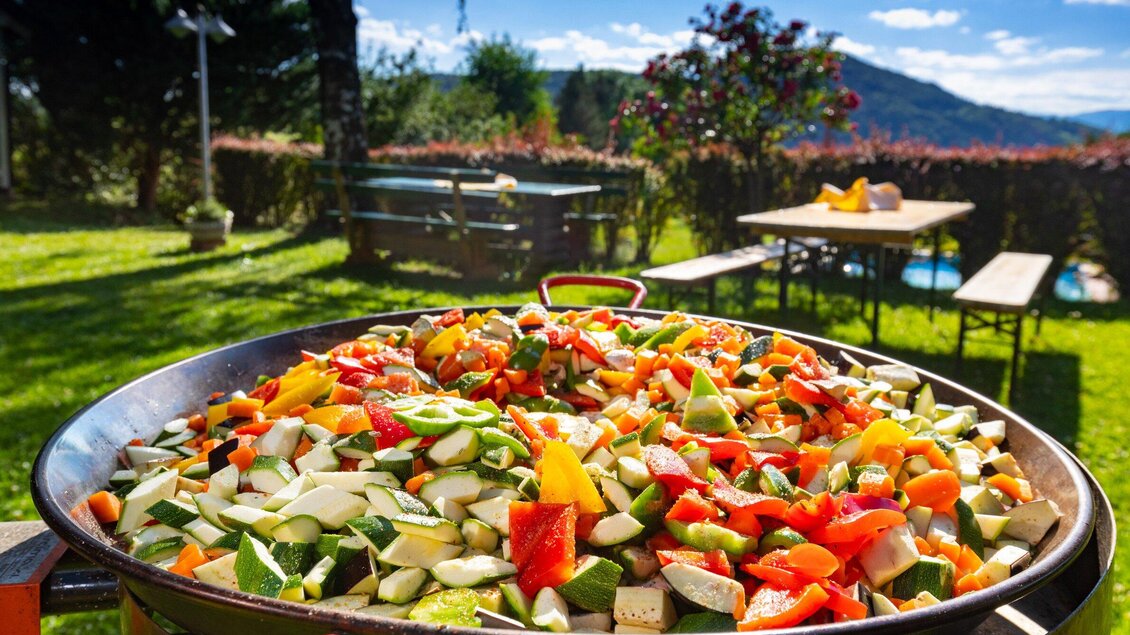 Bunte Gemüseschüssel auf einem Grill im Freien. Im Hintergrund eine grüne Wiese und blauer Himmel. | © TV Region Graz - Harry Schiffer