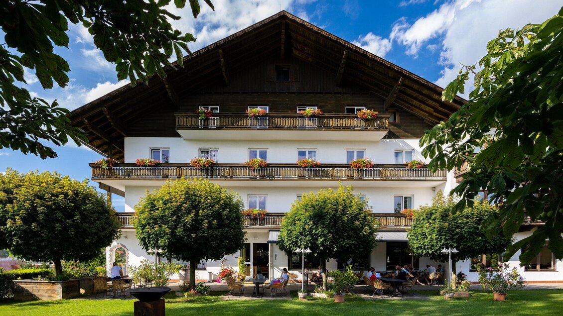Ein malerisches Hotel mit einem großen Balkon und schönen Blumen. Umgeben von grünen Bäumen und einem einladenden Garten. | © TV Region Graz - Harry Schiffer