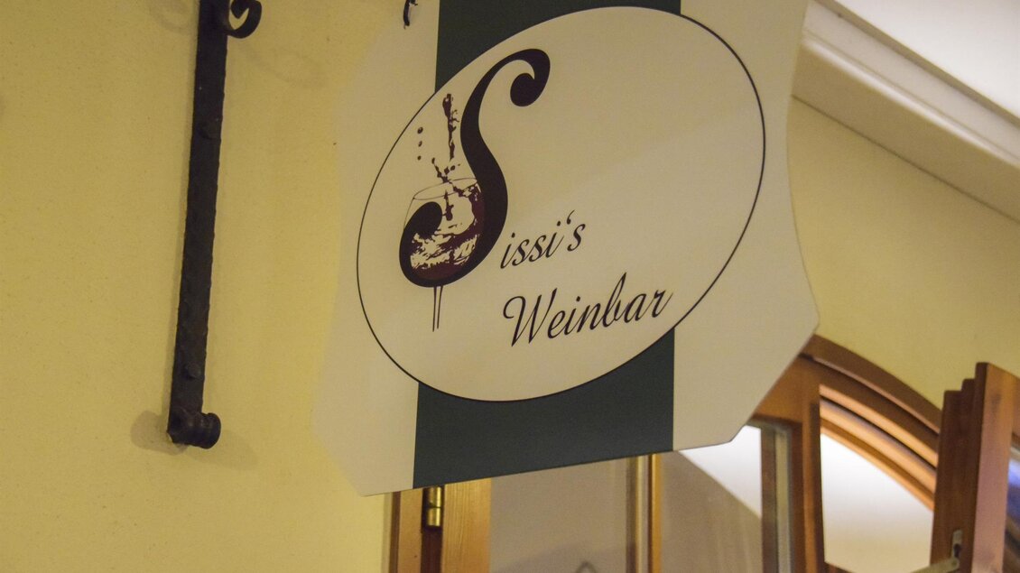 Ein Schild mit dem Namen „Sissi's Weinbar“. Es ist in einem elegant gestalteten Design gehalten. | © Sissi´s Weinbar