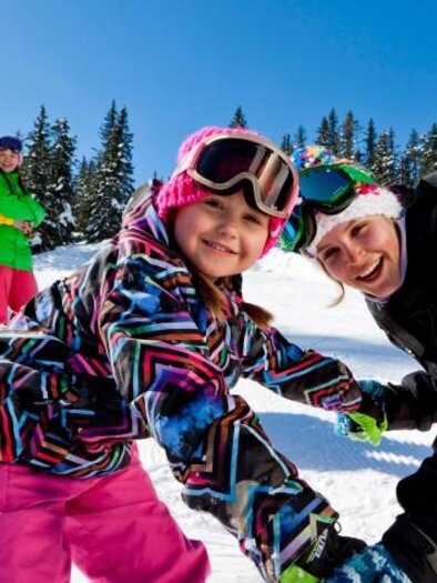 A cheerful family skiing in the snow.  
Children and adults are enjoying the sun and the winter landscape. | © Planneralm/Tom Lamm