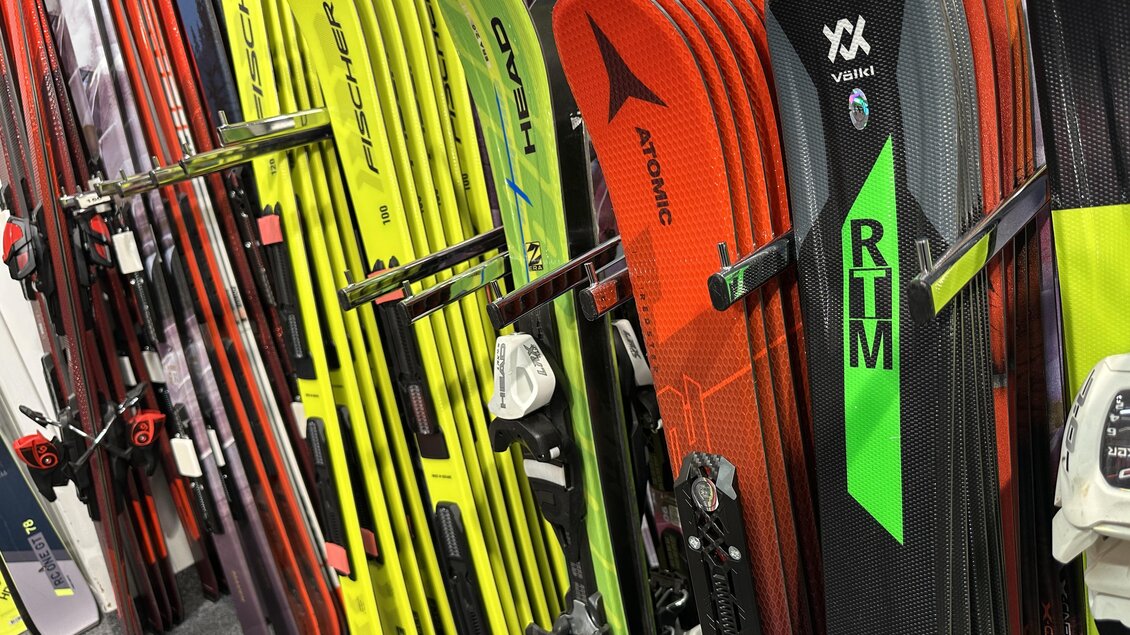 Eine Auswahl an verschiedenen Skiern in einem Geschäft. Die Skier haben verschiedene Farben und Marken. | © SkiWilly
