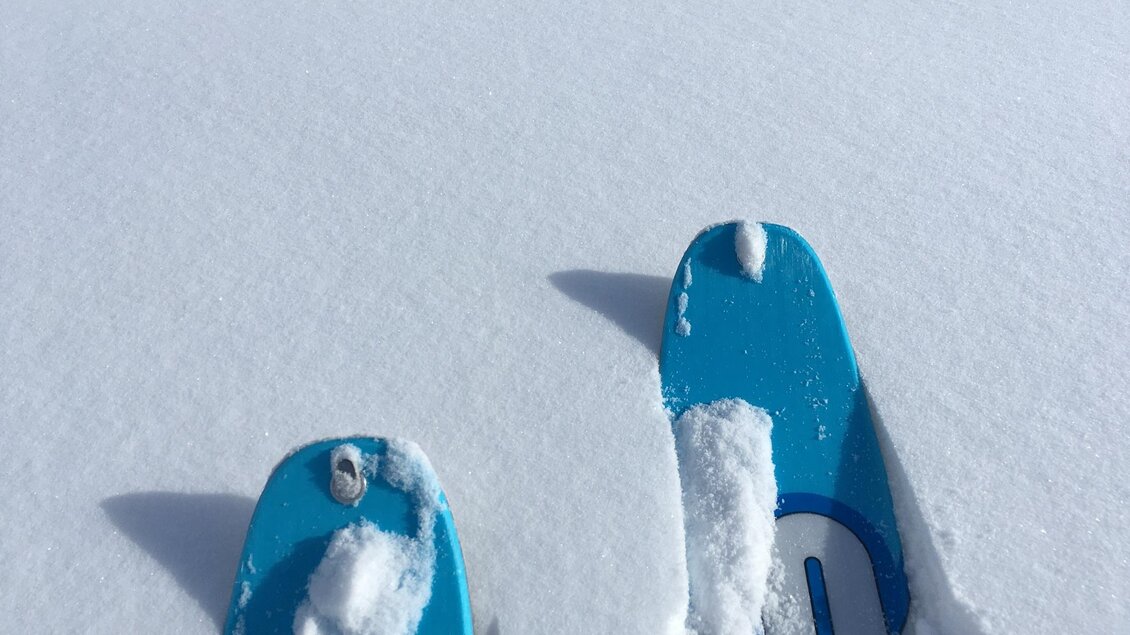 Schneeschuhe im frischen, unberührten Schnee. Der Himmel ist klar und die Landschaft wirkt friedlich. | © Mias Photoart