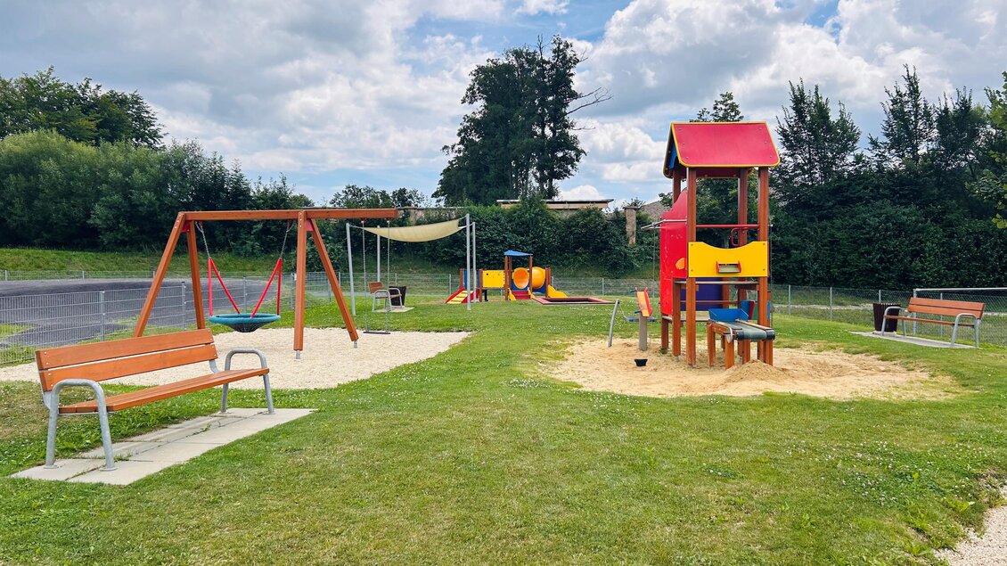 Ein kinderfreundlicher Spielplatz mit Schaukeln, einer Rutsche und einer Sandinsel. Darüber hinaus gibt es einige Bänke zum Sitzen. | © Tourismus Vorau