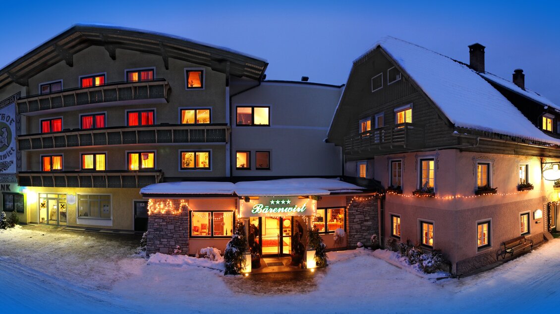 Ein gemütliches Hotel inmitten einer schneebedeckten Landschaft. Die Fenster leuchten sanft in der Dämmerung und schaffen eine einladende Atmosphäre. | © Bärenwirt