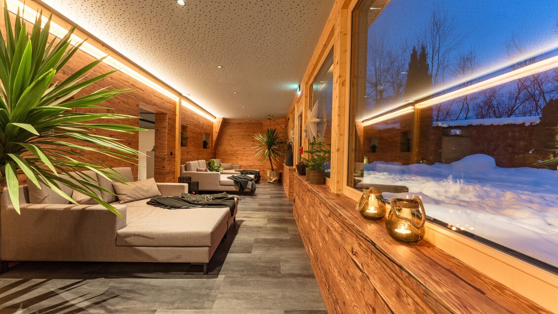 Ein gemütlicher Raum mit Holzverkleidung und großen Fenstern, die einen Blick auf die schneebedeckte Landschaft bieten. Die Einrichtung ist modern und lädt zum Entspannen ein. | © baerenwirt.com